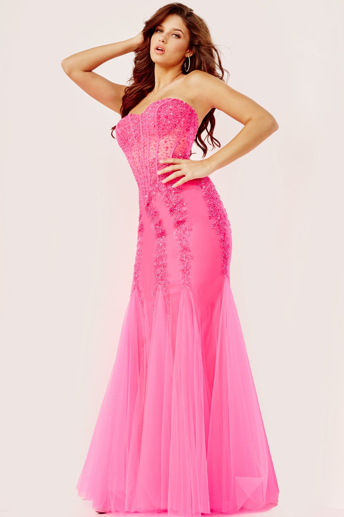 A woman poses in the Long Strapless Sweetheart Jovani Prom Dress 5908, featuring beaded embellishments and sheer panels, standing against a plain light background.